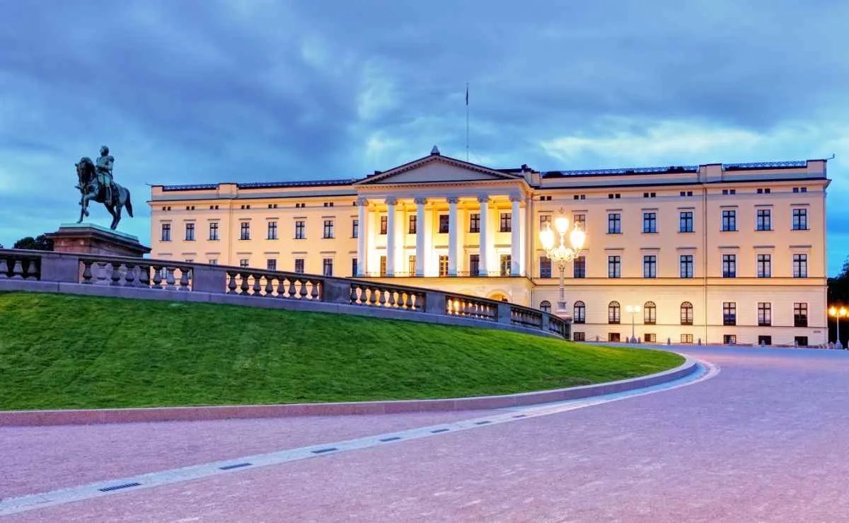 The Royal Palace in Oslo illuminated at dusk with the statue of King Karl Johan.