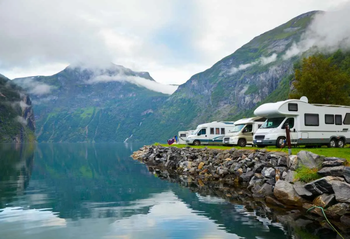 A group of campers parked in front of the Geirangerfjord in Norway.