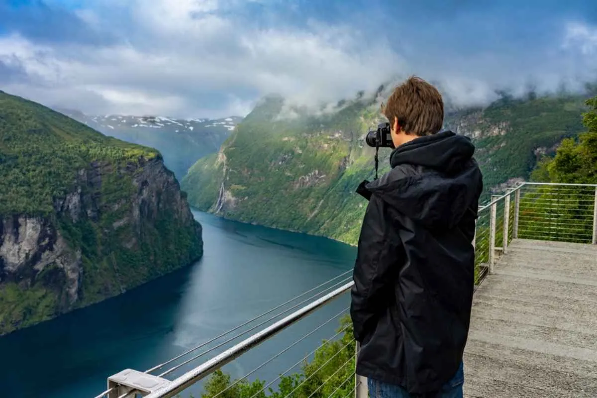 Hiker at Ornesvingen photographs Geirangerfjord