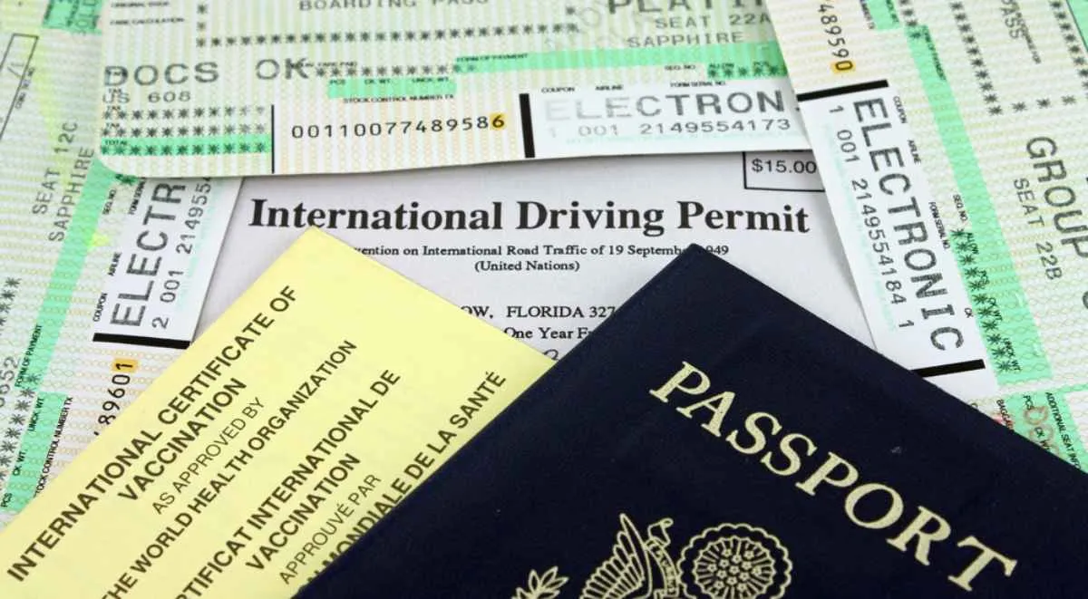 A collection of papers relating to the documentation required for traveling and driving abroad lie scattered on a flat surface.