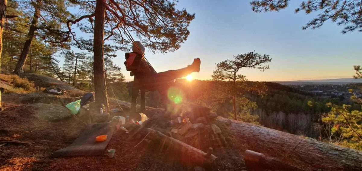 A bundled-up boy swings on a swing in a camping area near Oslo.