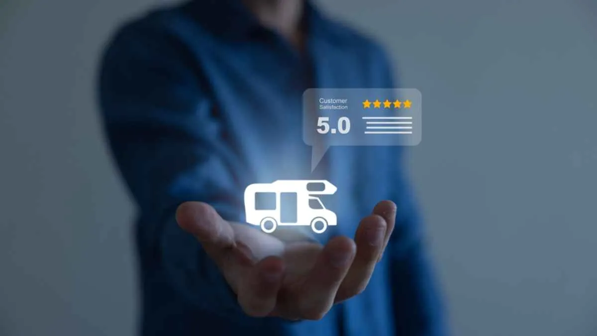 Vector image of a luminous campervan suspended in the hand of a blurred man over which appears another vector of an internet review rating the service with 5 stars.