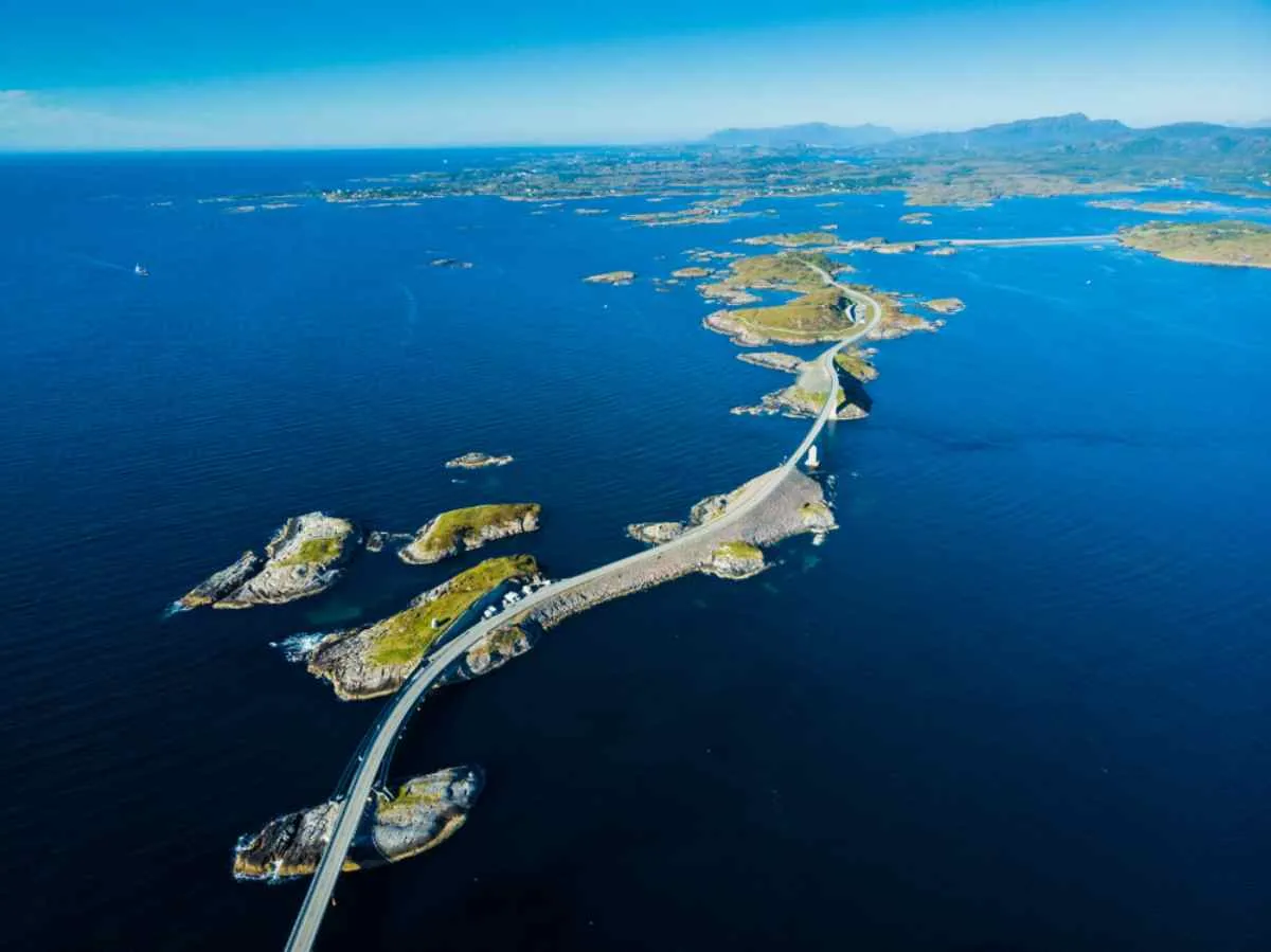 Aerial view of the spectacular Norwegian highway stretching over the Atlantic Ocean and small islands in a straight line separated from the mainland.