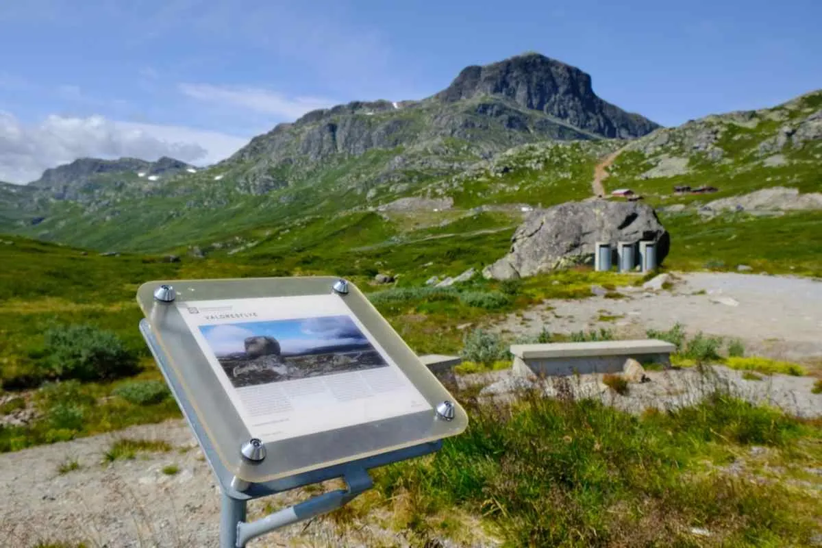 A viewpoint located at the foot of the Valdresflye hills in Norway with a sign informing of the surrounding mountains.