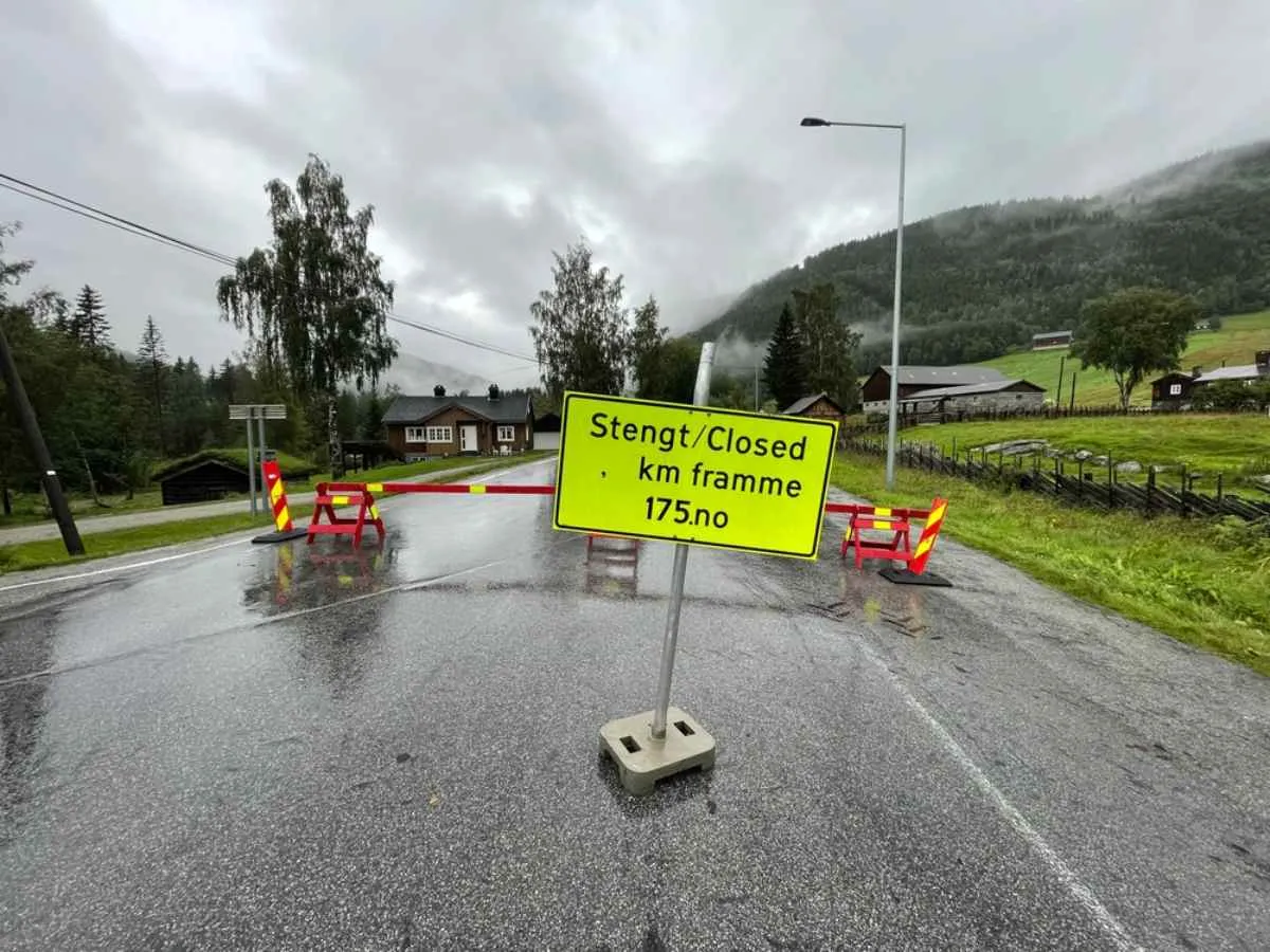 An apparently wet Norwegian road appears cut off with local and English writing on a road sign