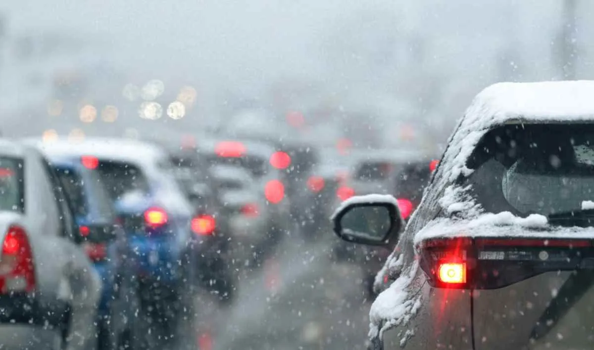 A line of cars remain stationary on what looks like a road cut off by winter traffic