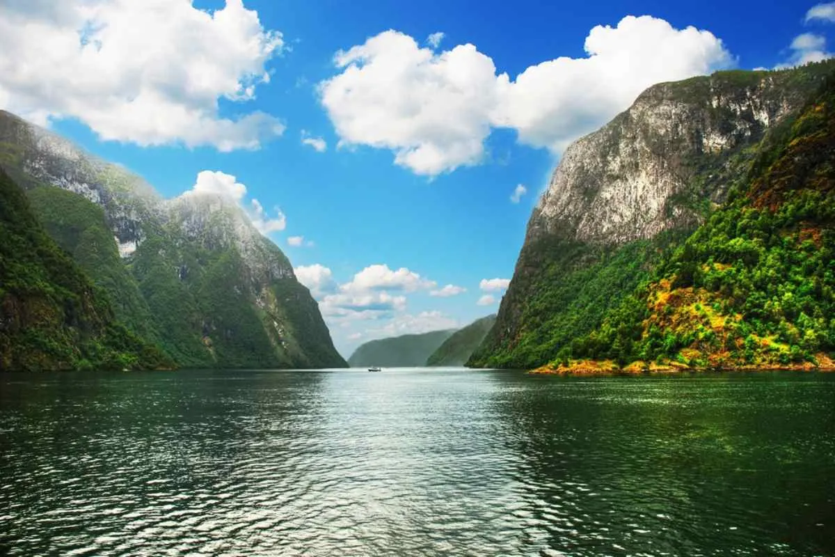 Beautiful postcard of the calm waters of Hardangerfjord in Norway during a practically clear day.