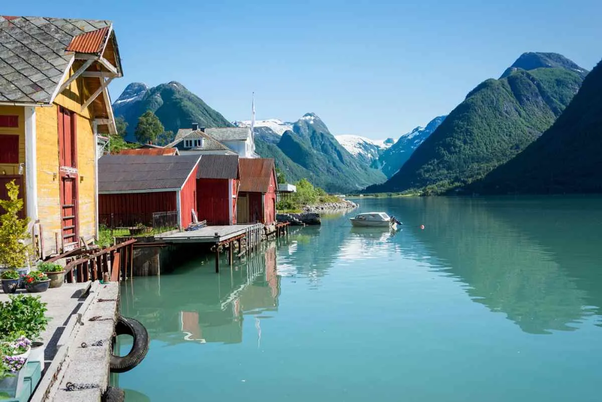 Small harbor with turquoise waters and beautiful mountains in the background located in Sognalsfjora.