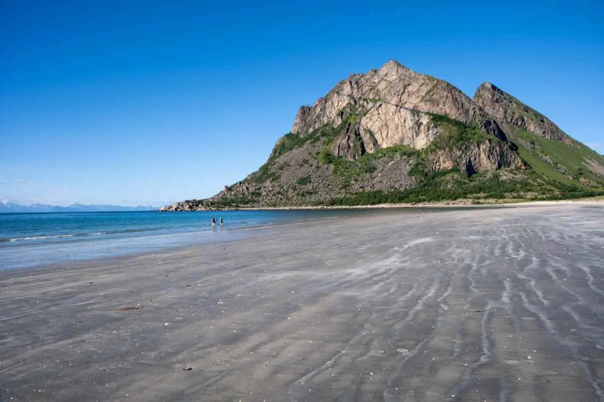 General view of the Bosaden beach in Engeloya, Norway with a stone massif of tens of meters presiding over it.