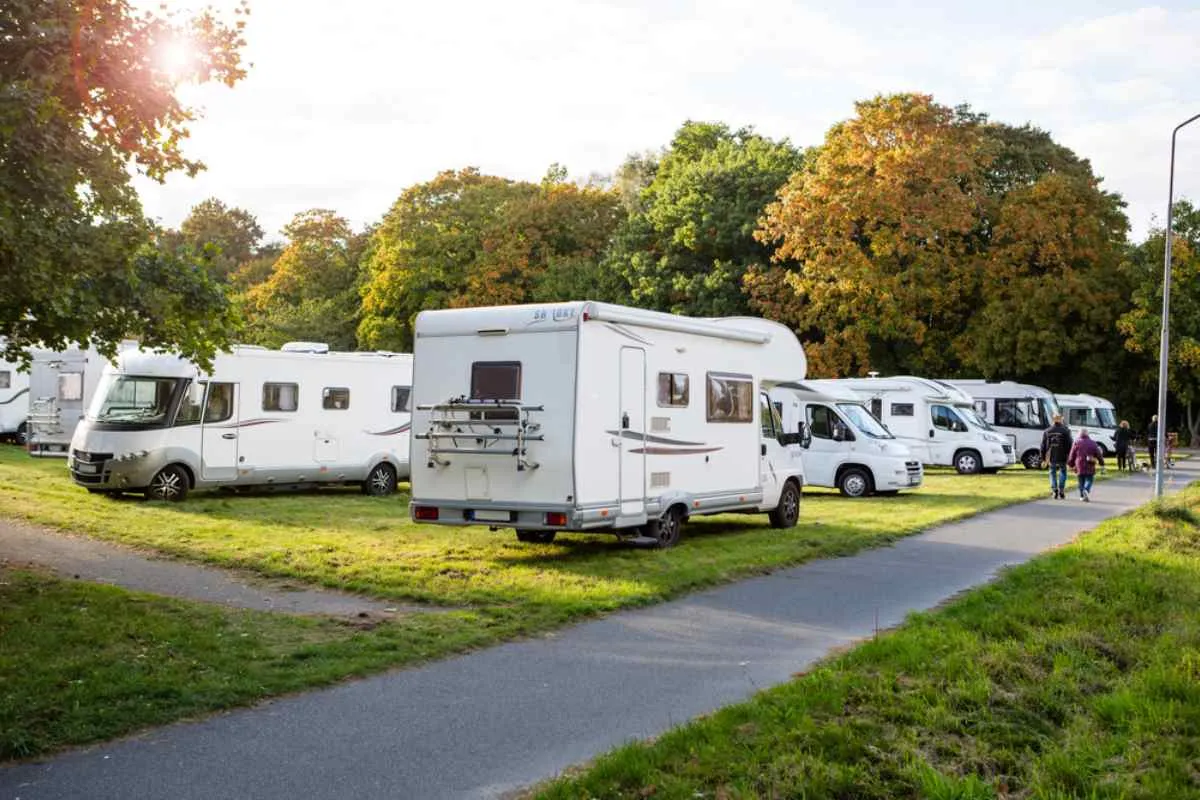 Dozens of campervans and motorhomes remain parked in a green area set aside for camping.