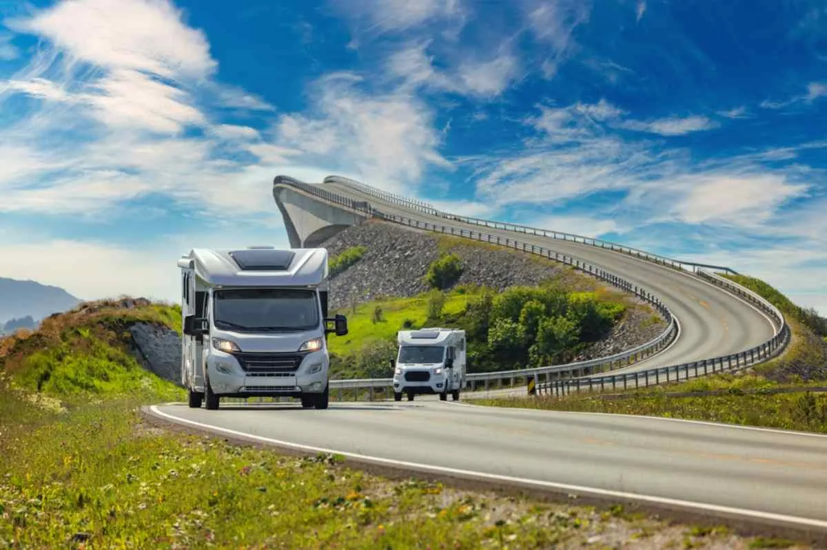 Two motorhomes cruise along Norway's Atlantic Ocean Road on a sunny day.