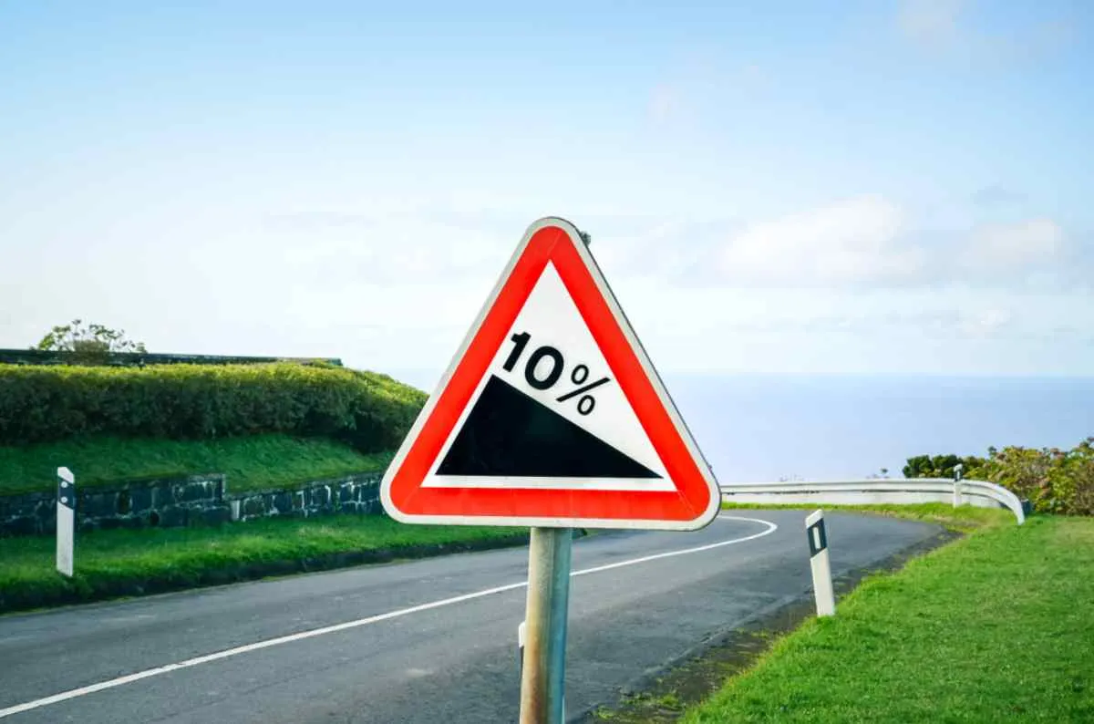 A triangular sign in Norway indicates a downhill by means of the icon of a steep hill with 10%.