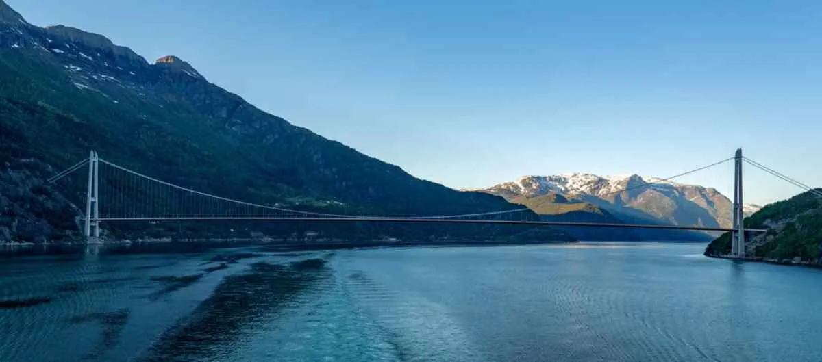 General view of the spectacular Hardanger Suspension Bridge in Norway during a time of day with no sunlight shining on it.
