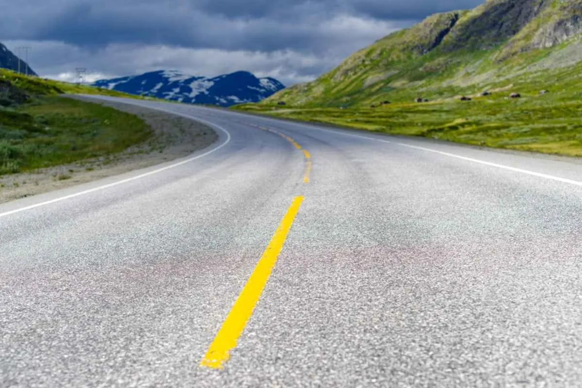 Empty stretch of RV52 scenic road in Norway winding through green valleys and mountains.