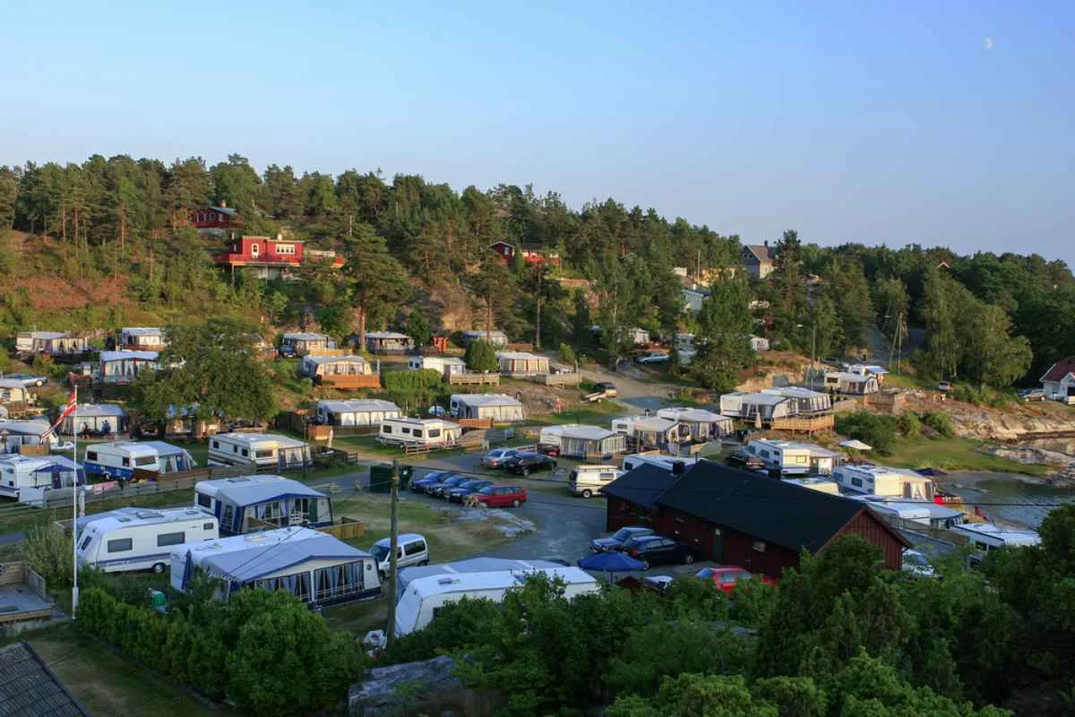 Aerial view of a camping site with caravans and cabins surrounded by trees in Kristiansand