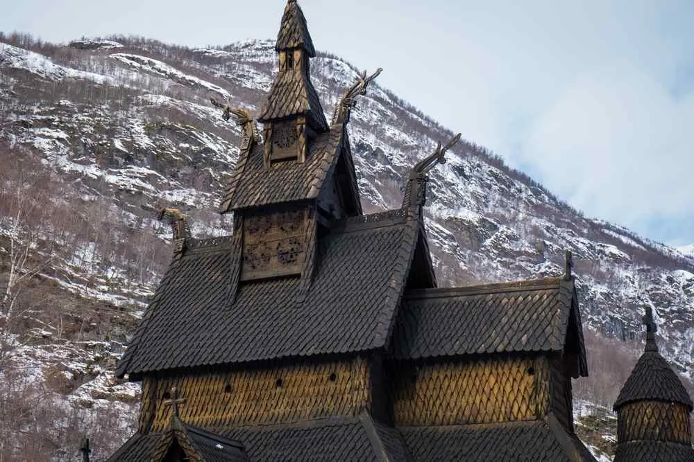 Borgund Stave Church surrounded by snow-covered mountains in Norway.
