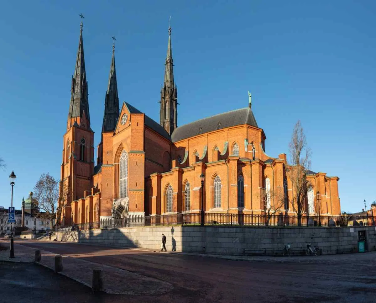Vista aérea desde el exterior de la catedral de Uppsala que muestra la grandiosidad de este edificio rojizo con tres grandes torres