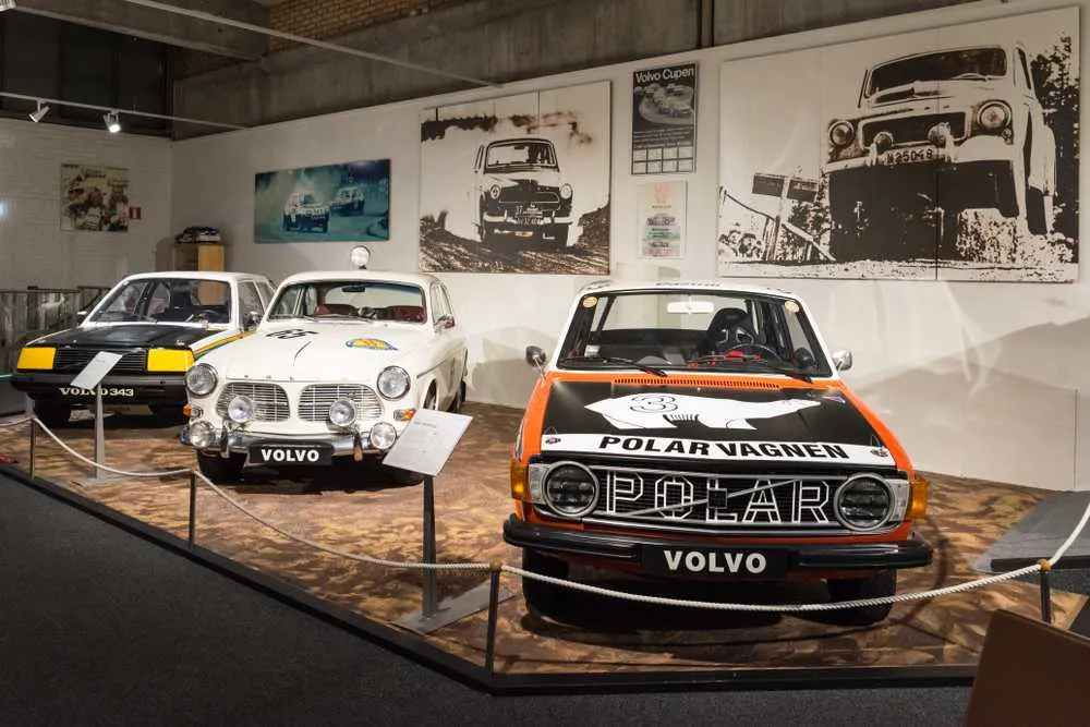 Vista detallada de una de las zonas del Museo Volvo de Gotemburgo, con varios coches clásicos expuestos frente a un mural con fotografías.