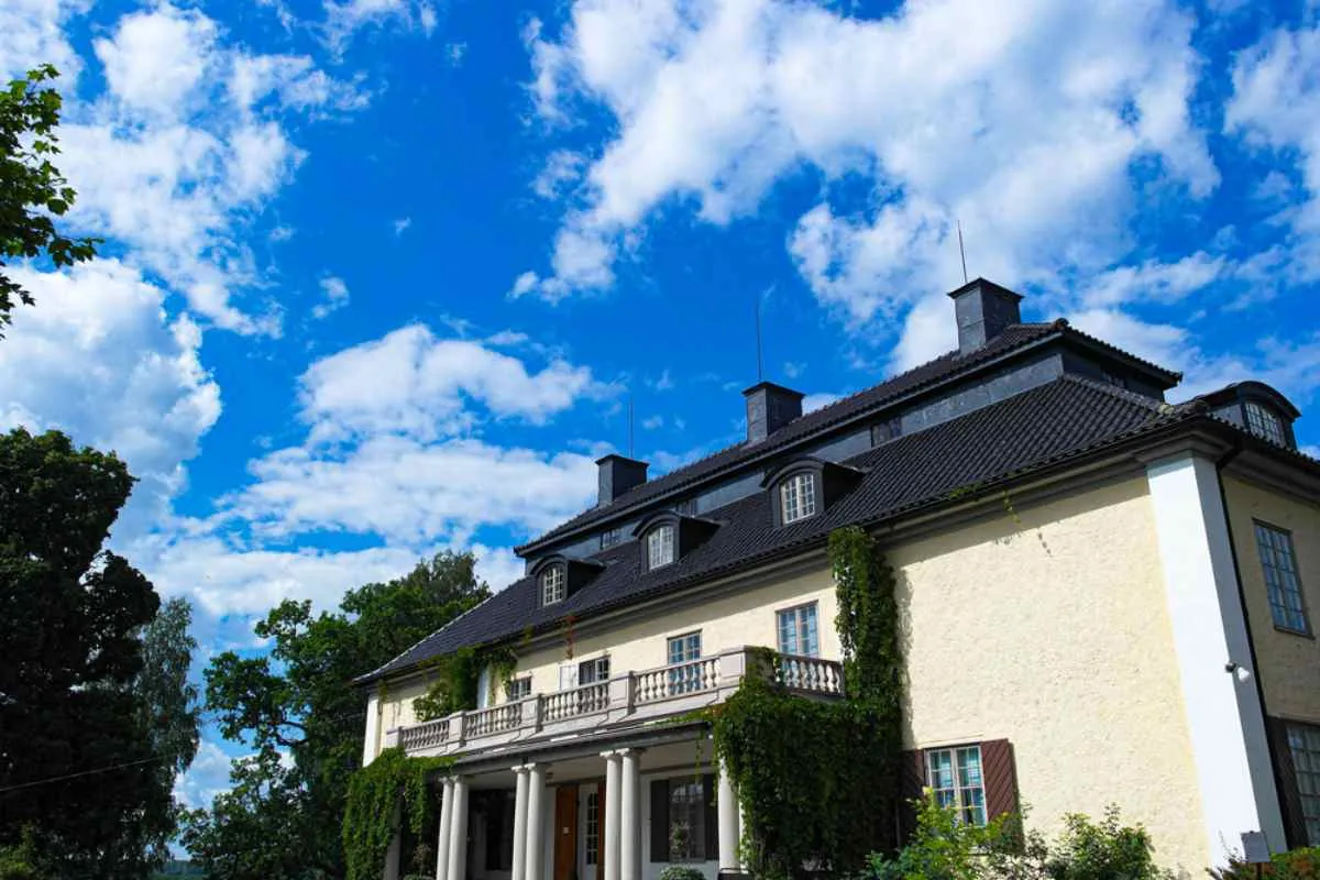 La tenuta di Marbacka nella contea di Värmland, in Svezia, dimora della scrittrice Selma Lagerlöf, con muri ricoperti di edera e un cielo azzurro.