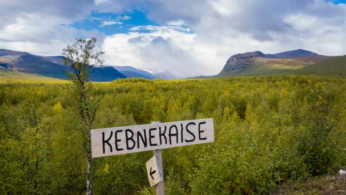 Dettaglio di un cartello in legno con la scritta “Kebnekaise” in un’area naturale svedese.