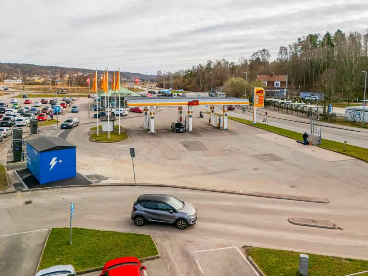 Vista dal drone di una normale stazione di servizio in Svezia, con diverse auto che fanno rifornimento alle pompe e altre che se ne vanno.