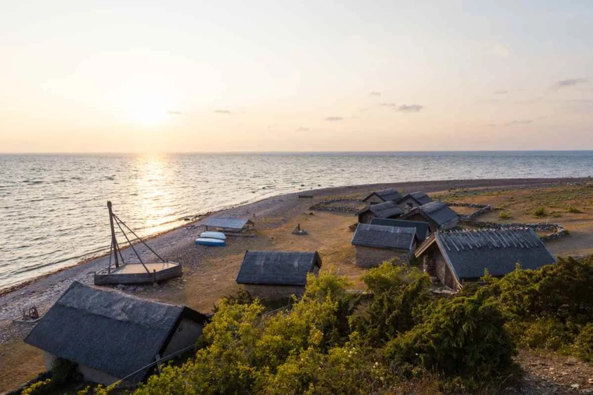 Tradizionali capanne da pesca su una spiaggia rocciosa di Öland al tramonto.