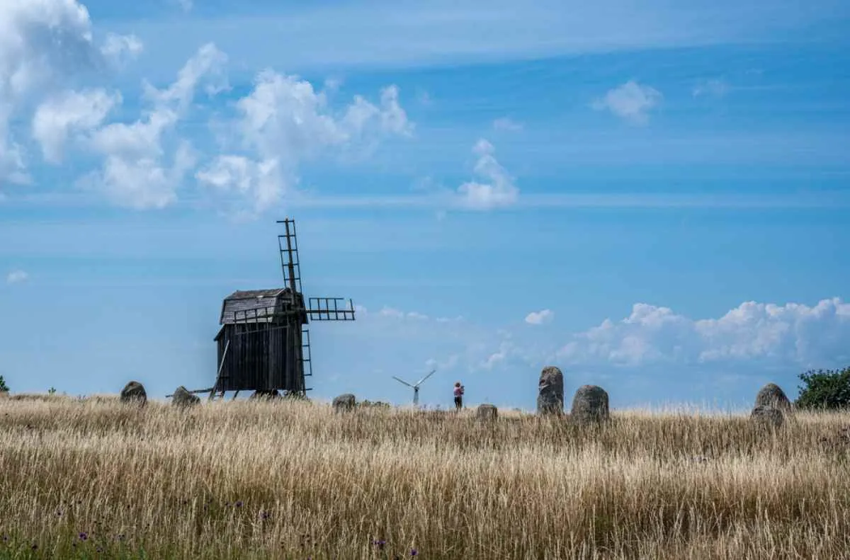 Un vecchio mulino a vento in legno e dei menhir a Stora Alvaret, sull’isola di Öland.