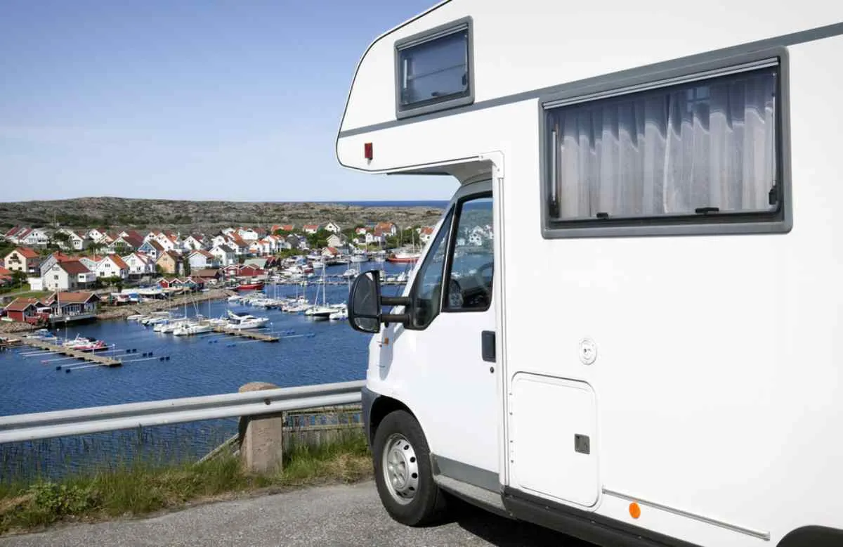Un camper bianco è parcheggiato davanti a un porto in Svezia.