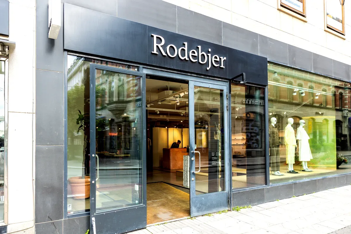 L’ingresso del negozio Rodebjer in Svezia, che mette in mostra la moda scandinava moderna attraverso grandi vetrine dal design minimalista.