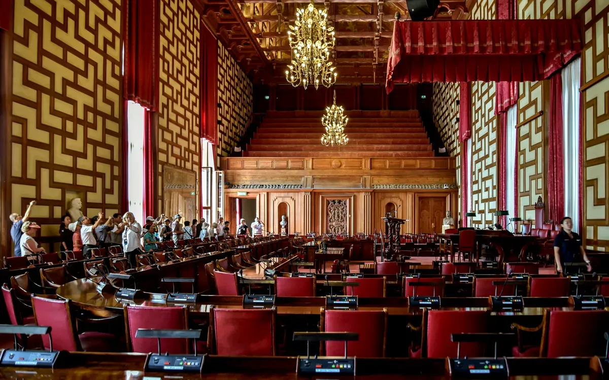 Interno della sala del consiglio nel municipio di Stoccolma, con lampadari e decorazioni in legno.