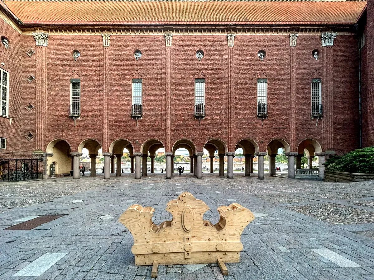 Il cortile del Municipio di Stoccolma, con una scultura in legno raffigurante una corona e la facciata in mattoni dell’edificio