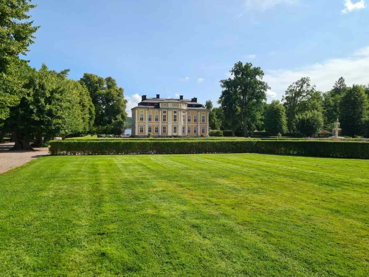 Vista general del castillo de Steninge, en Suecia, desde la perspectiva de sus preciosos jardines verdes.