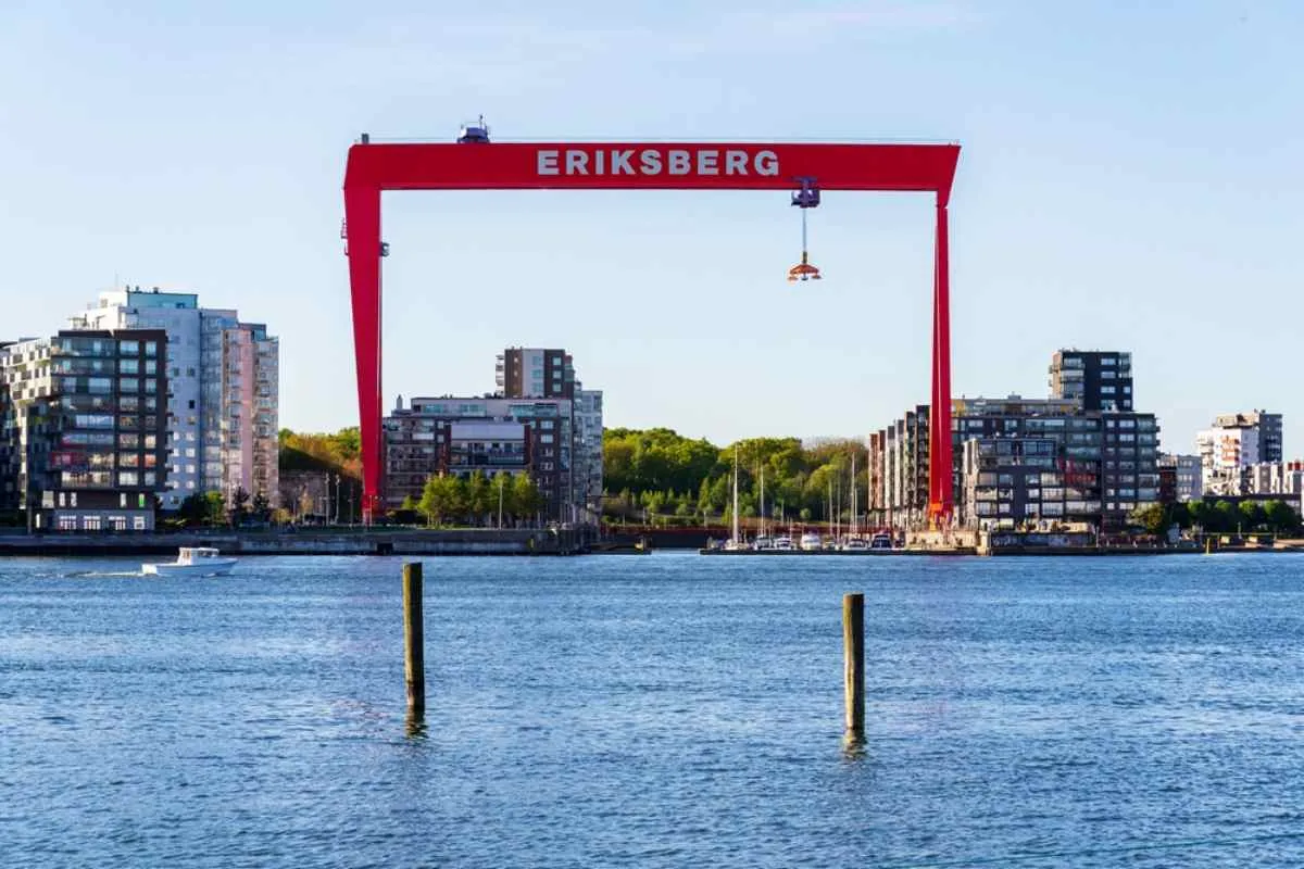 Vue sur la grue rouge d’Eriksberg et les appartements modernes en bord de mer à Göteborg, une étape urbaine très prisée lors d’un road trip dans le sud de la Suède.