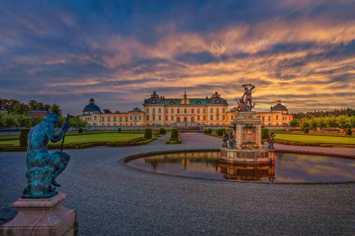 Il Palazzo di Drottningholm al tramonto con fontane e statue in primo piano: una gita di un giorno in stile reale appena fuori Stoccolma.