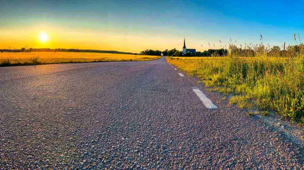 Una strada di campagna all’ora dorata con una chiesa all’orizzonte vicino a Västerås: un classico percorso nella campagna svedese partendo da Stoccolma.