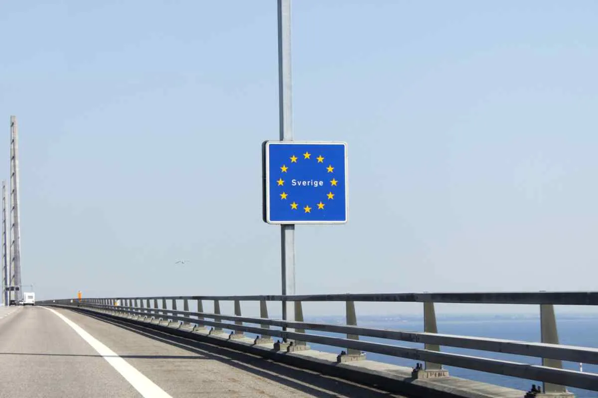 Señal de tráfico que indica la entrada a Suecia dentro del Espacio Schengen en un puente que cruza aguas abiertas.