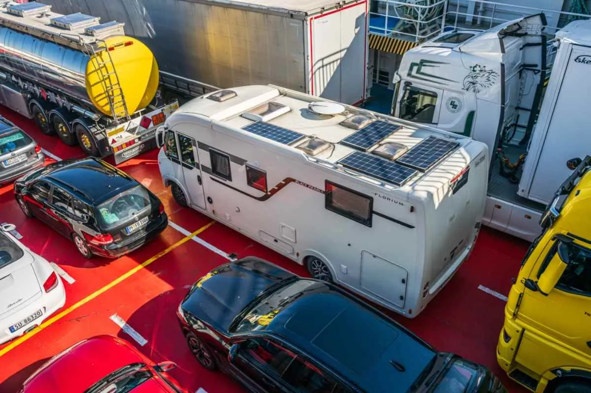 Husbil med solpaneler på taket ombord på en bilfärja på väg E39 i Norge.