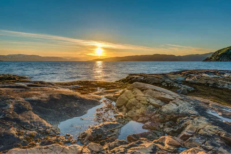 Die Mitternachtssonne spiegelt sich im Meer – Mitternachtssonne in Norwegen